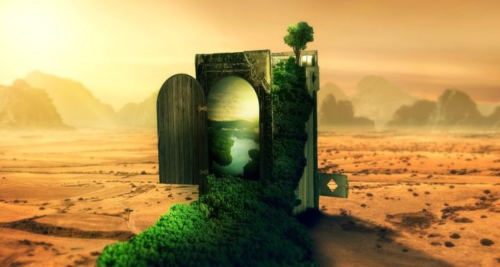 Portale di pietra ricoperto di vegetazione verde in un paesaggio desertico e arido